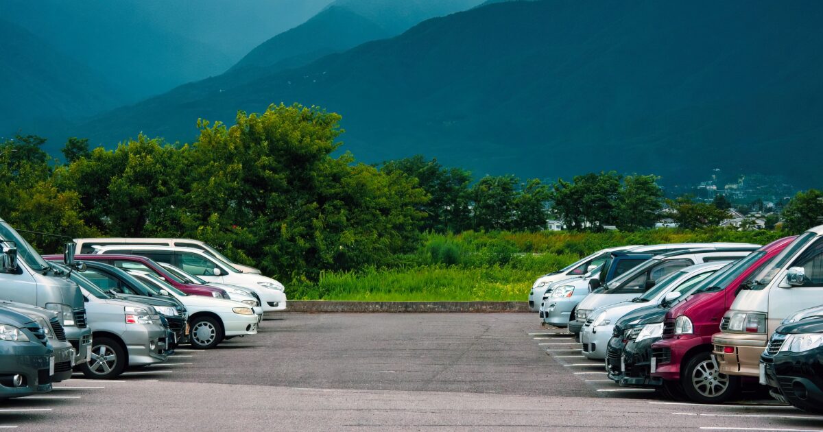 山を背景にした郊外の広い駐車場