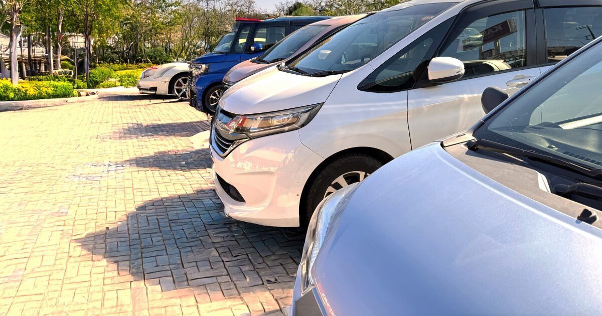 舗装された駐車場に並ぶコンパクトカー