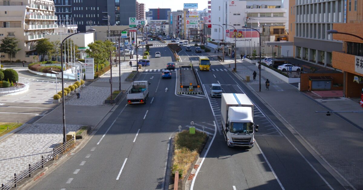 都市部の幹線道路を走行する車とトラック