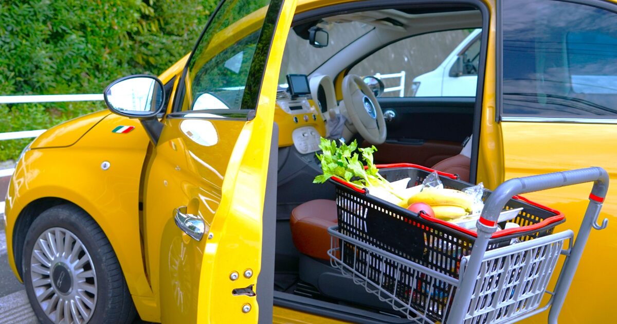 買い物カートと黄色い車の開いたドア